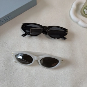 Detail of vintage cat-eye sunglasses with gold metal accents on black and cream resin frames