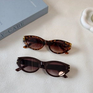 Close-up of retro cat-eye sunglasses in tortoiseshell and brown with gold hinges