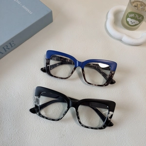 Close-up of stylish large frame cat-eye glasses in blue and black tortoiseshell patterns