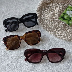 Détail de lunettes de soleil œil de chat en noir, écaille de tortue et brun rougeâtre