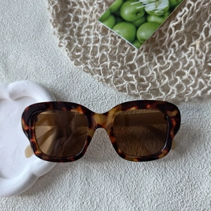 Gros plan détaillé des lunettes de soleil écaille avec monture ambre et verres marrons