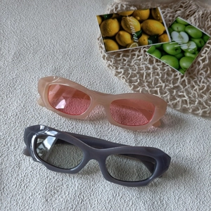 Lunettes de soleil œil de chat rétro avec montures épaisses ondulées rose et gris