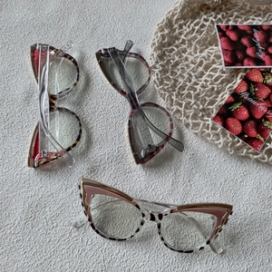 Detailed close-up of cat-eye frames in leopard print, tortoiseshell, and transparent grey