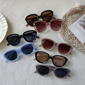 Close-up of stylish oversized sunglasses in multiple colors on a textured background