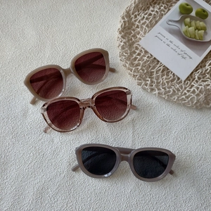 Detailed view of large retro round sunglasses in beige, tea pink, and taupe colors