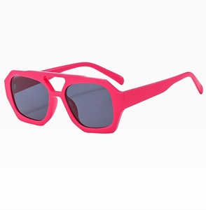 Detail of neon pink geometric sunglasses with double bridge and dark UV lenses