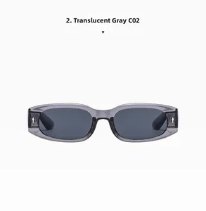 Nahaufnahme der transparenten grauen Sonnenbrille mit silbernen Kreuznieten aus Metall