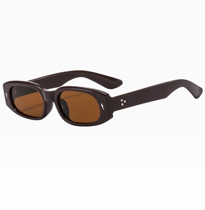 Detailansicht der braunen ovalen Sonnenbrille mit Metallstern-Nieten am Rahmen