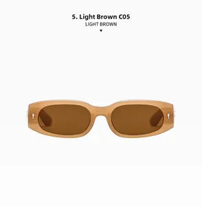 Detail einer hellbraunen rechteckigen Sonnenbrille mit silbernen Nieten und braunen Gläsern