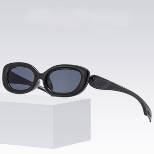 Retro black oval sunglasses with thick frames on a minimalist white display plinth