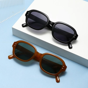Retro thick-frame oval sunglasses in glossy black and amber brown with silver stud detail