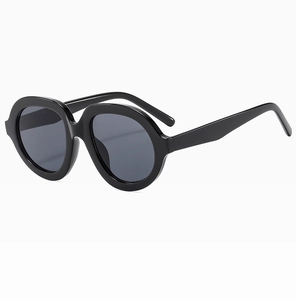 Dettaglio di occhiali da sole ovali vintage con montatura nera e lenti grigio scuro