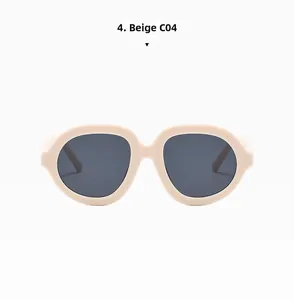 Dettaglio degli occhiali da sole grandi beige con lenti grigio scuro in stile minimalista