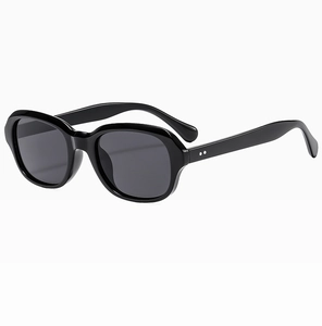 Détail de lunettes de soleil ovales vintage avec rivets argentés sur monture noire brillante