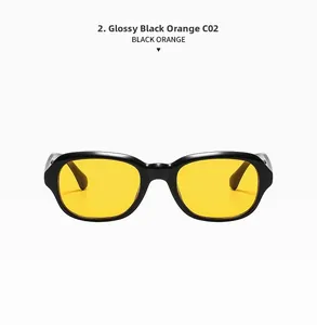 Détail de lunettes de soleil ovales rétro noir brillant avec des verres orange vifs