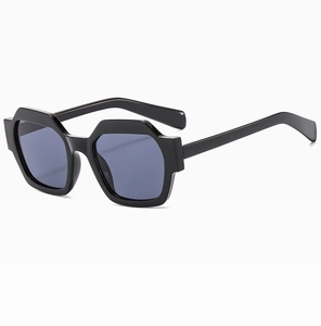 Detail of geometric hexagonal oversized sunglasses with thick black frame and dark lenses