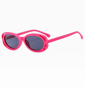 Détail de lunettes de soleil ovales roses avec monture ajourée et verres foncés