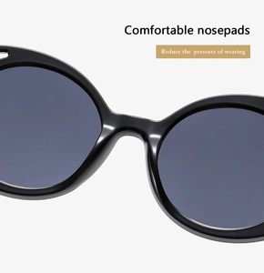 Detail view of comfortable integrated nose pads on large round black sunglasses