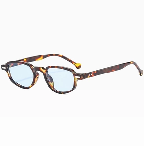 Détail de lunettes ovales vintage en écaille avec verres bleus et rivets en métal