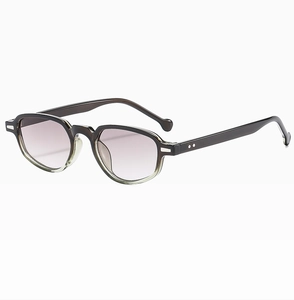 Détail de lunettes de soleil ambre translucide avec rivets argentés et verres dégradés