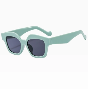 Detail view of stylish mint green geometric square frame sunglasses with dark lenses