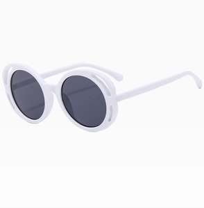 Detail of oversized white round sunglasses with stylish hollow frame design and dark lenses