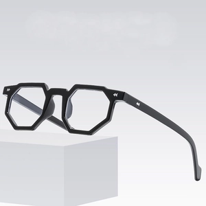 Black hexagonal geometric glasses frame with silver arrow metal accents on white cube