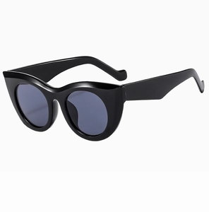 Close-up of black cat eye sunglasses with glossy resin frames and dark grey lenses