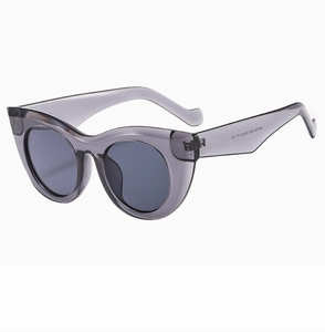 Detail view of cat eye sunglasses with gray transparent resin frame and dark gray lenses