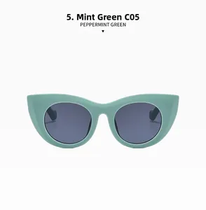Detail view of cat eye sunglasses in mint green frame with dark grey lenses