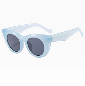 Detail of light blue cat-eye sunglasses with dark grey lenses and high-quality frame