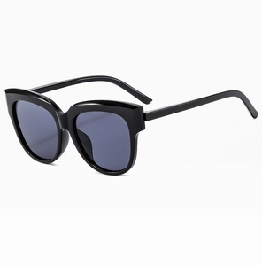 Détail latéral des lunettes de soleil œil de chat noires à monture épaisse et verres foncés