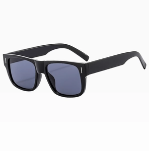 Details einer quadratischen schwarzen Sonnenbrille mit blauen Gläsern und Nieten