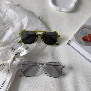 Occhiali da sole poligonali per bambini con montatura verde e trasparente in stile retro