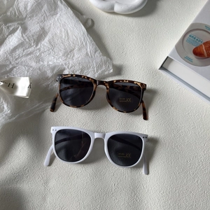 Detail of UV400 kids sunglasses in leopard and white frames with polarized lenses