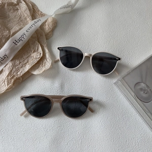 Gros plan de lunettes de soleil crème et marron avec charnières métalliques