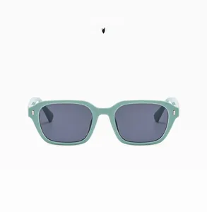 Flat lay of mint green square sunglasses with dark grey lenses and silver accents