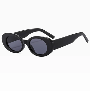 Detail view of oval retro sunglasses with thick black frame and grey lenses