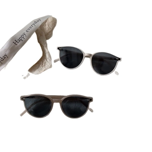 Lunettes de soleil minimalistes pour enfants avec montures crème et nude, verres foncés