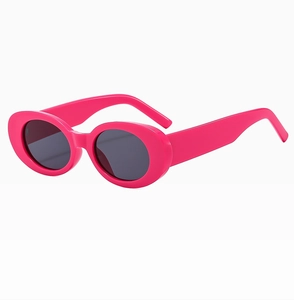 Close-up of rose pink oval vintage sunglasses with dark lenses and wide temples