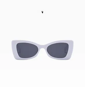 Detail view of vintage white rectangular sunglasses with dark lenses and stylish metal studs