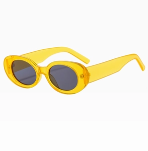 Detail of retro oval sunglasses with translucent yellow frame and dark grey lenses
