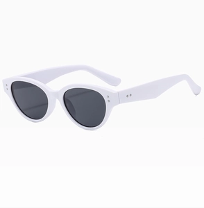 Detail view of white cat-eye sunglasses with dark grey lenses and silver rivet accents