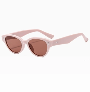 Detail of pink cat-eye sunglasses with brown lenses and silver rivet accents on the frame