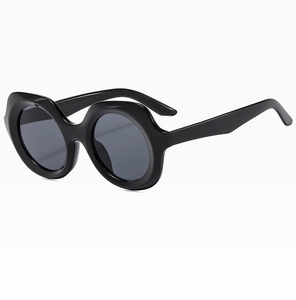 Détail de lunettes de soleil noires avant-garde avec montures ondulées et verres foncés