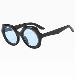 Détail de lunettes de soleil vintage avec monture noire ondulée et verres bleu clair