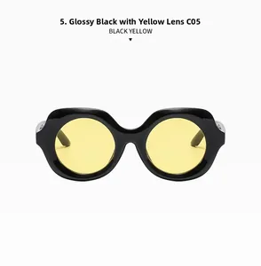 Détail de lunettes de soleil polygonales rétro avec monture noir brillant et verres jaunes