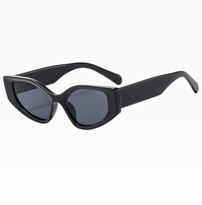 Detail view of bold black cat-eye sunglasses with thick frame and dark UV-protective lenses