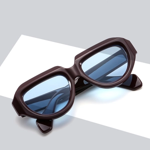 Modern geometric sunglasses with thick brown frames and light blue translucent lenses