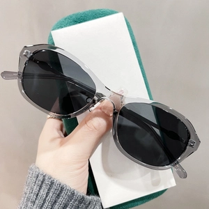 Makro-Detail der transparenten grauen Cat-Eye-Sonnenbrille mit dunklen Gläsern auf Samt